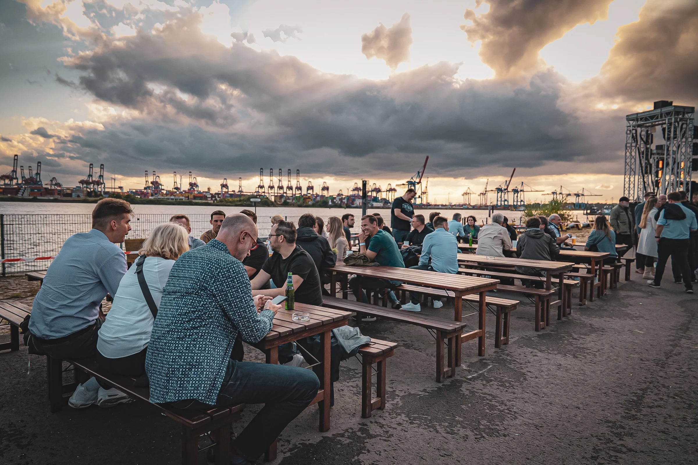Gäste unterhalten sich auf dem Platz mit Blick auf die Elbe